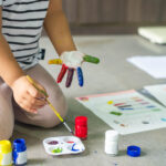 girls are painting on their own fingers to make art, multi color, homework, funny