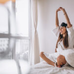 Woman in bed wearing sleeping mask