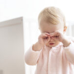 Baby girl crying and rubbing her eyes